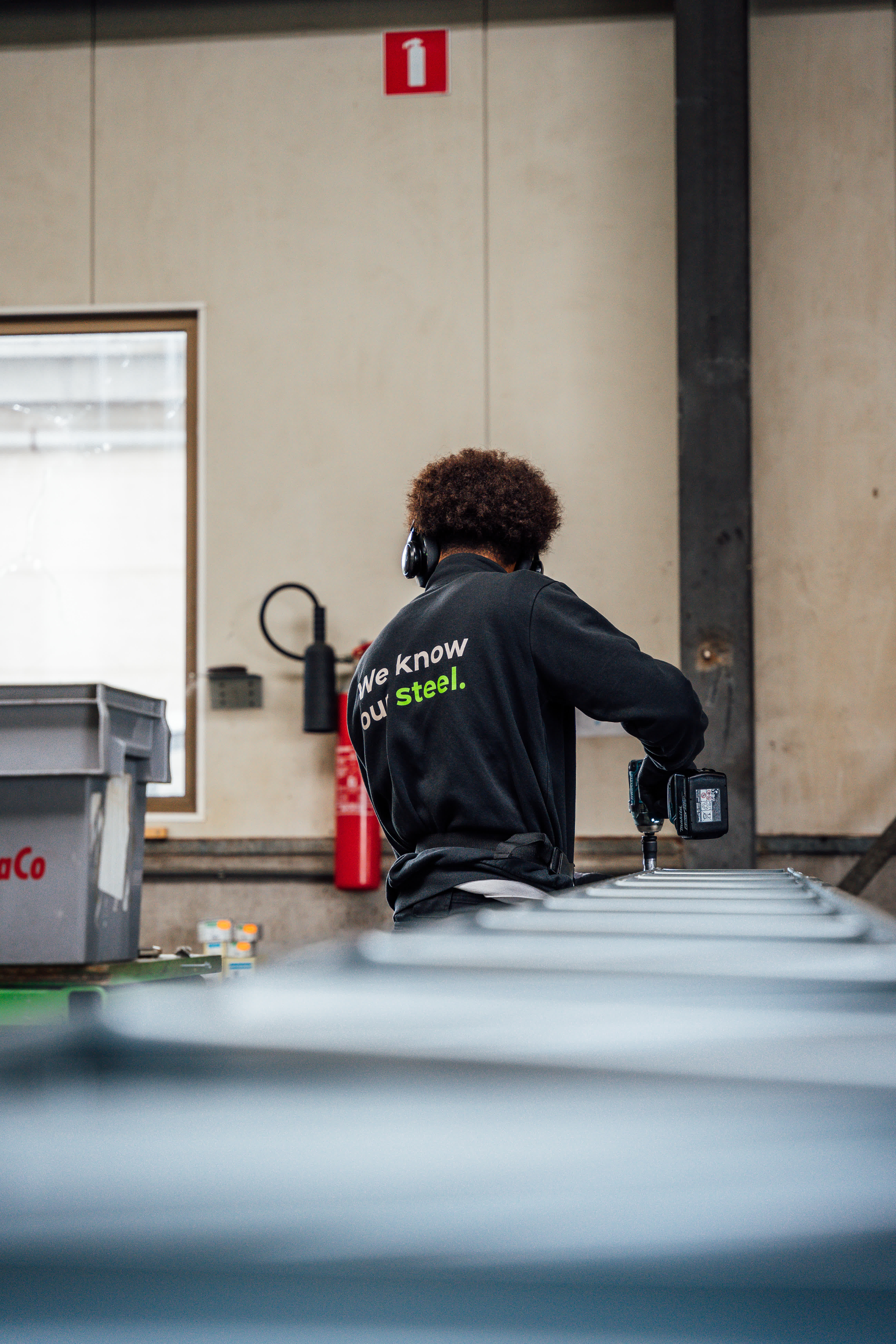 medewerker die aan het werk is met logo quicksteel op de rug